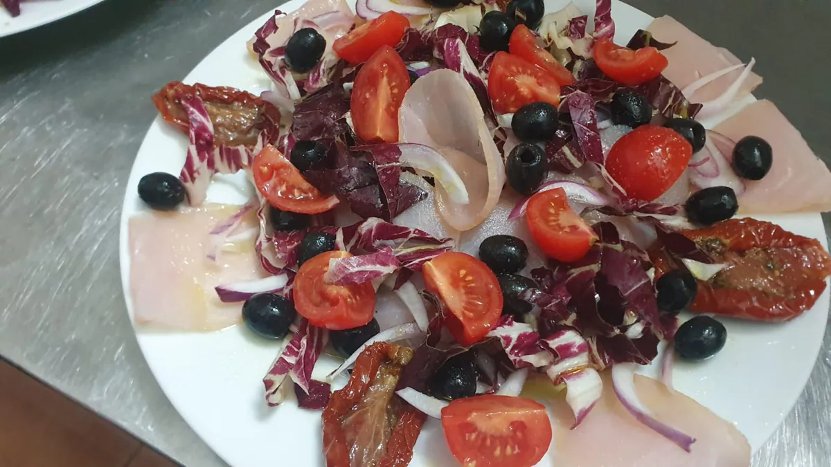 Carpaccio di pesce con radicchio, olive e pomodorini
