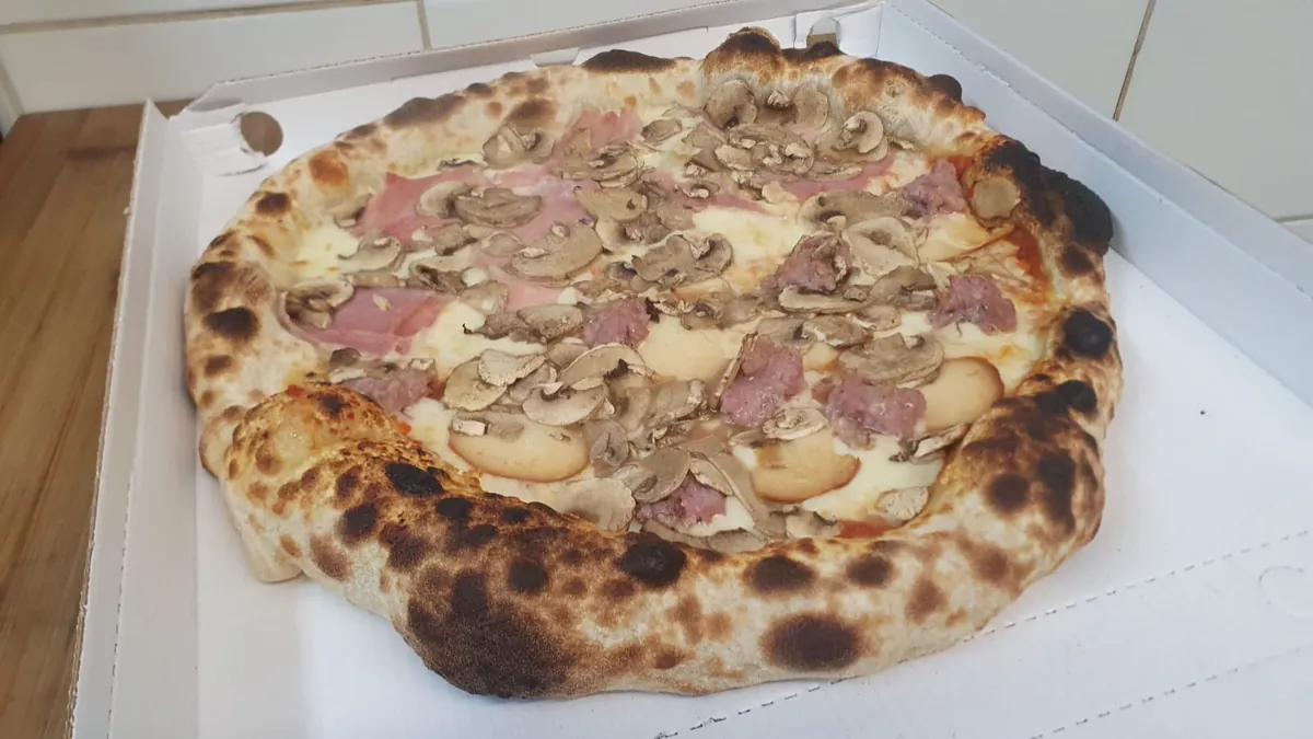 Pizza con prosciutto cotto, funghi e salsiccia